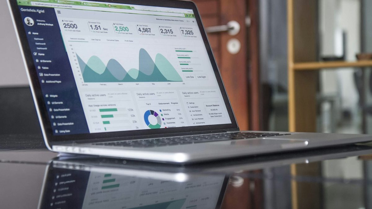 A laptop showing an analytics dashboard with traffic and conversion charts